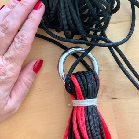 The bundle of strands bound with twine just below a metal ring